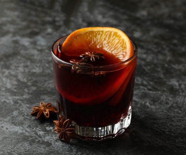 Glass of mulled wine on black smokey table