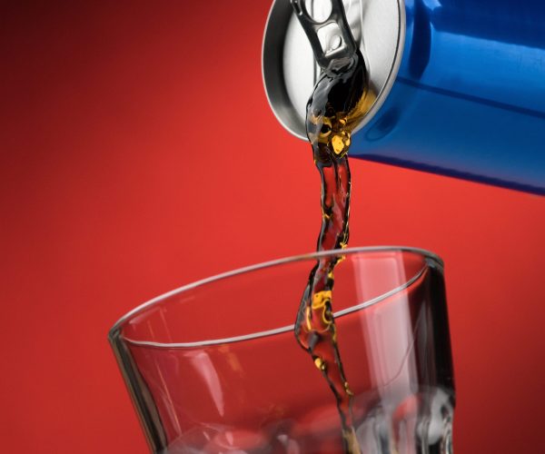 Pouring a refreshing sugary soft drink from a can into a glass